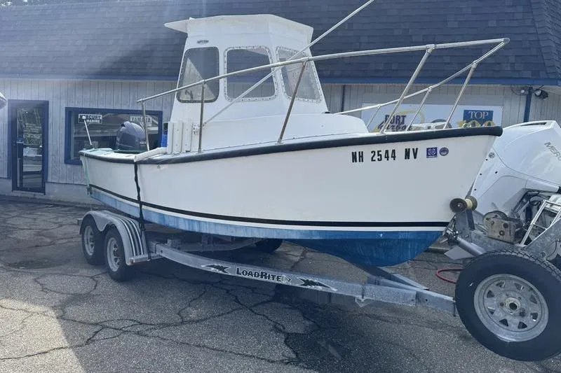 Slide: The Image of 2001 ROS Boats 19 RUNABOUT on trailer, parked outside a building. - 3