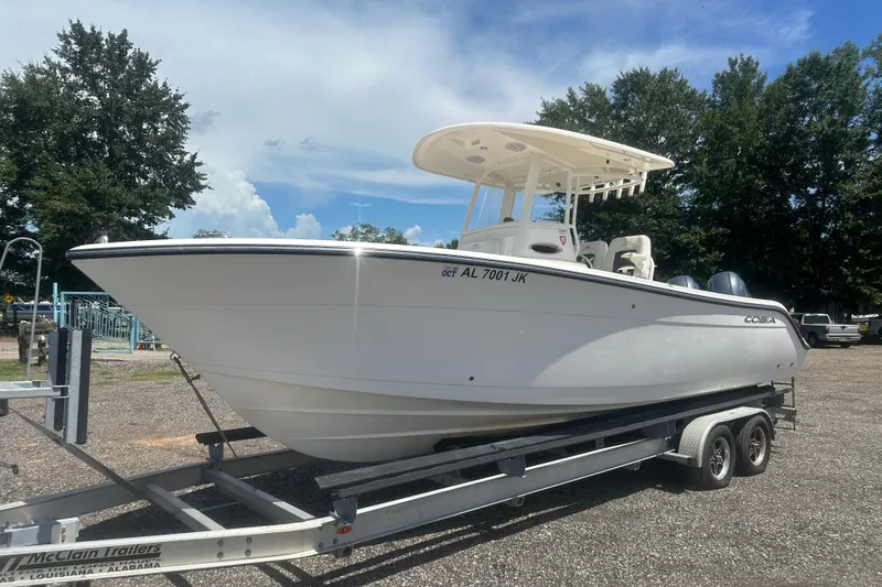 The Image of 2023 Cobia 262 Center Console boat on trailer, parked outdoors under a clear sky. - 1