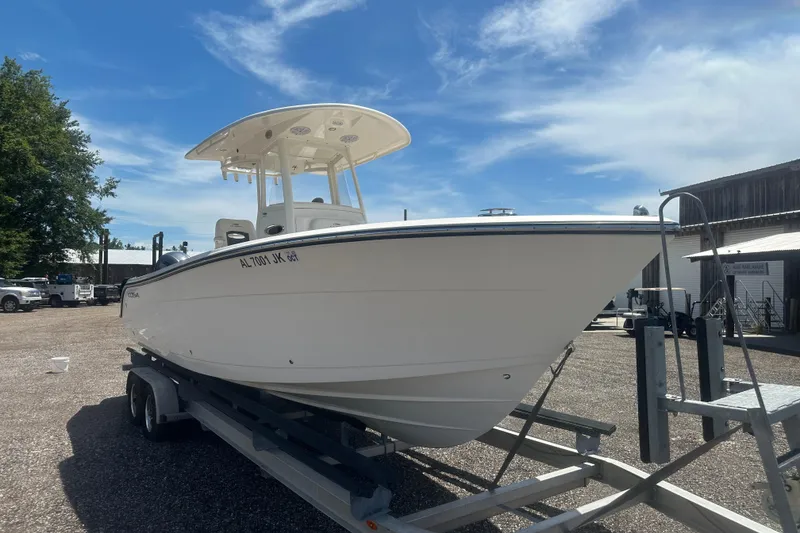 Slide: The Image of 2023 Cobia 262 Center Console boat on trailer under clear blue sky. - 10