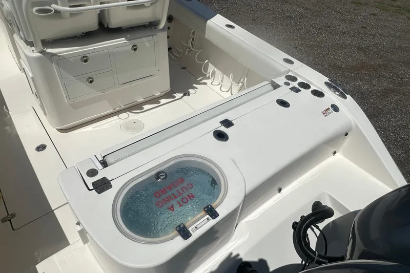 Slide: The Image of 2023 Cobia 262 Center Console boat interior with storage and livewell. - 12
