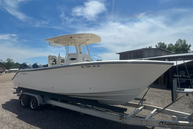 Slide: The Image of 2023 Cobia 262 Center Console boat on trailer under clear blue sky. - 9