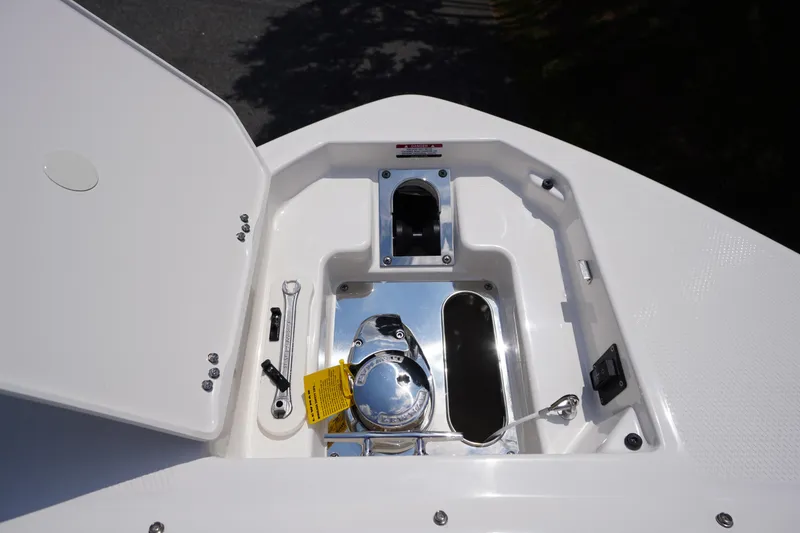 Slide: The Image of 2025 Chaparral 280 OSX boat anchor compartment with open hatch and tools. - 14