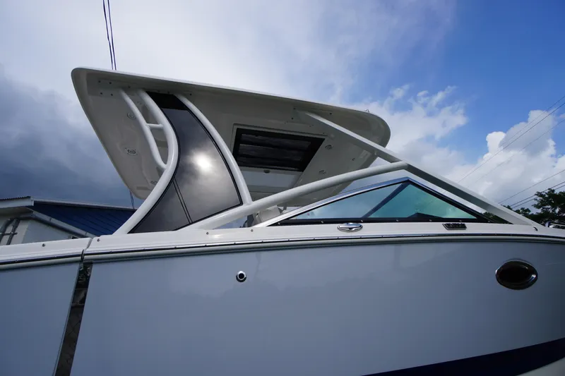 Slide: The Image of 2025 Chaparral 280 OSX boat, sleek design, viewed from below against a cloudy sky. - 47