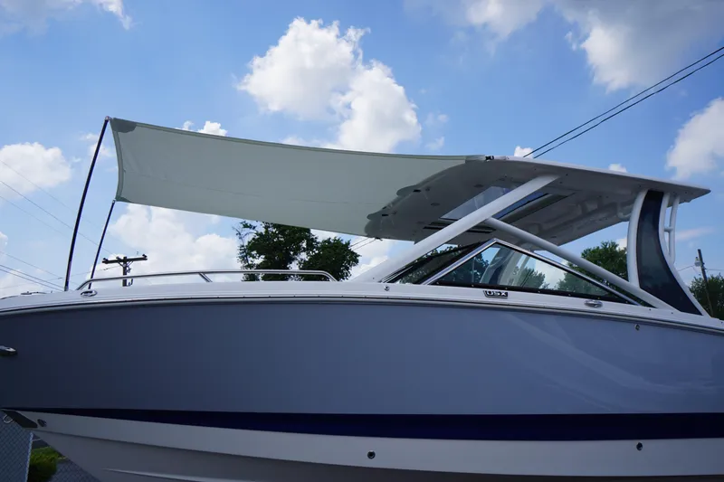 Slide: The Image of 2025 Chaparral 280 OSX boat with canopy under a blue sky. - 51