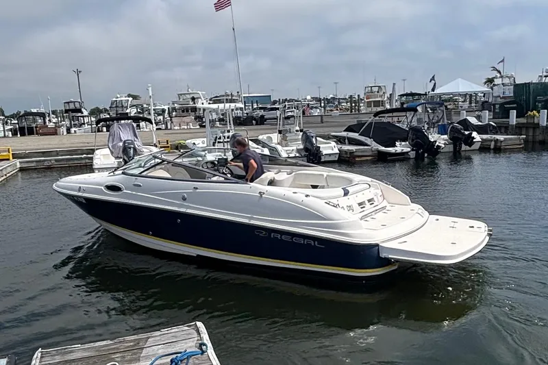 Slide: The Image of 2007 Regal 2400 Bowrider boat docked at marina with American flag in background. - 10