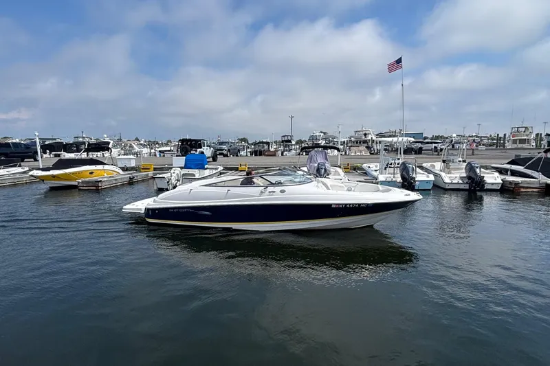 Slide: The Image of 2007 Regal 2400 Bowrider boat docked at a marina under a cloudy sky. - 12