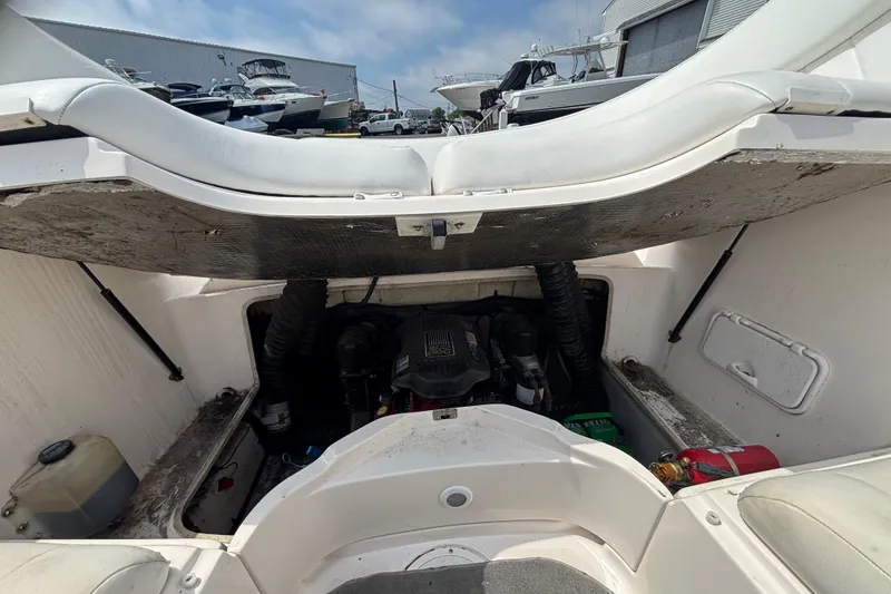 Slide: The Image of Open engine compartment of a 2007 Regal 2400 Bowrider boat, showing engine and storage area. - 14
