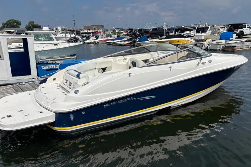 Slide: The Image of 2007 Regal 2400 Bowrider boat docked at a marina, featuring sleek design and spacious seating. - 2