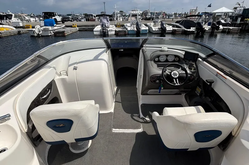 Slide: The Image of 2007 Regal 2400 Bowrider interior with steering wheel, seats, and docked boats in background. - 5