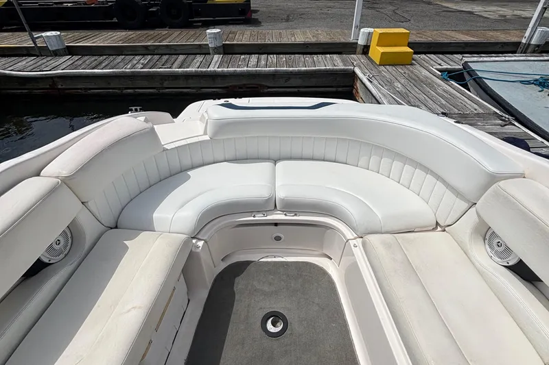 Slide: The Image of 2007 Regal 2400 Bowrider boat interior with white seating at dock. - 6