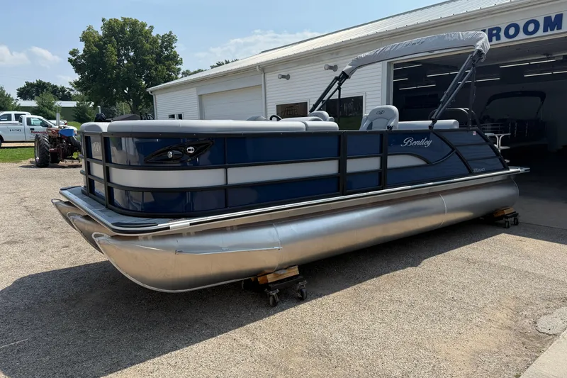 Slide: The Image of 2026 Bentley Pontoons Legacy 223 Swingback pontoon boat parked outside a showroom. - 3