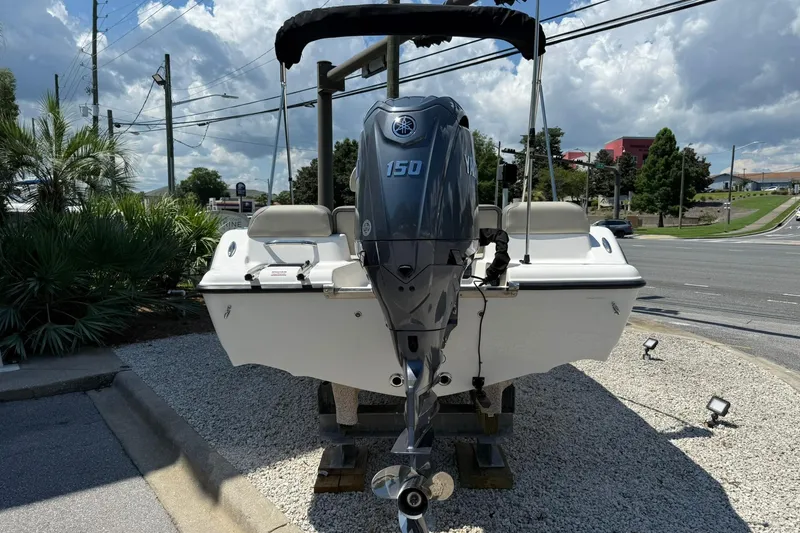 Slide: The Image of 2025 Key West 189 FS boat with Yamaha 150 engine, parked on gravel lot. - 2