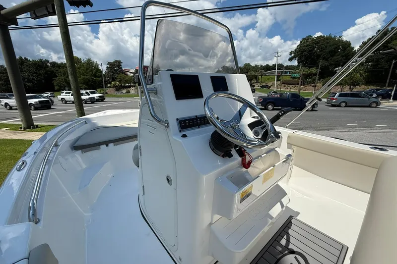 Slide: The Image of 2025 Key West 189 FS boat console with steering wheel and controls, parked near a road. - 7
