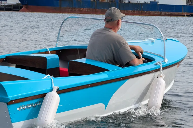 Slide: The Image of Man steering a 2025 Starcraft '57 Ski Champ boat on water. - 1