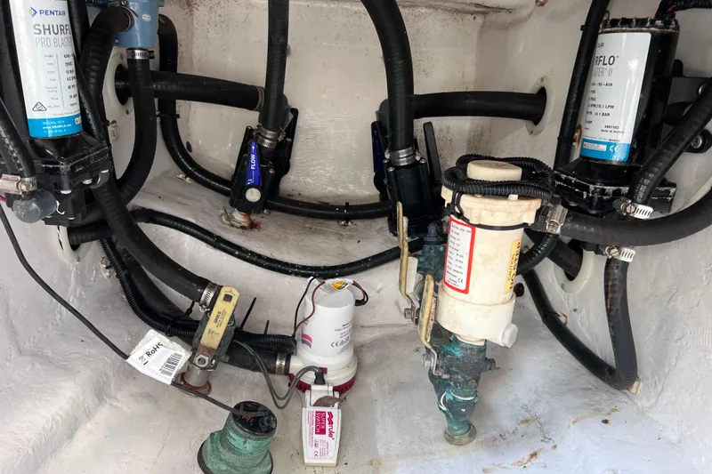 Slide: The Image of 2017 Contender 24 Sport boat plumbing system with pumps and hoses in the bilge area. - 20
