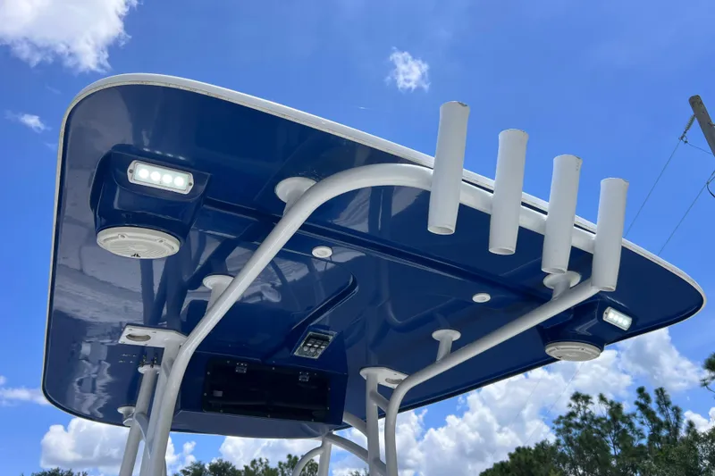 Slide: The Image of 2017 Contender 24 Sport boat T-top with rod holders and LED lights against blue sky. - 27