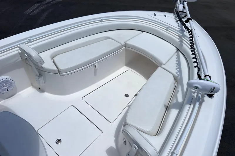 Slide: The Image of 2017 Contender 24 Sport boat interior with white cushioned seating and trolling motor. - 32