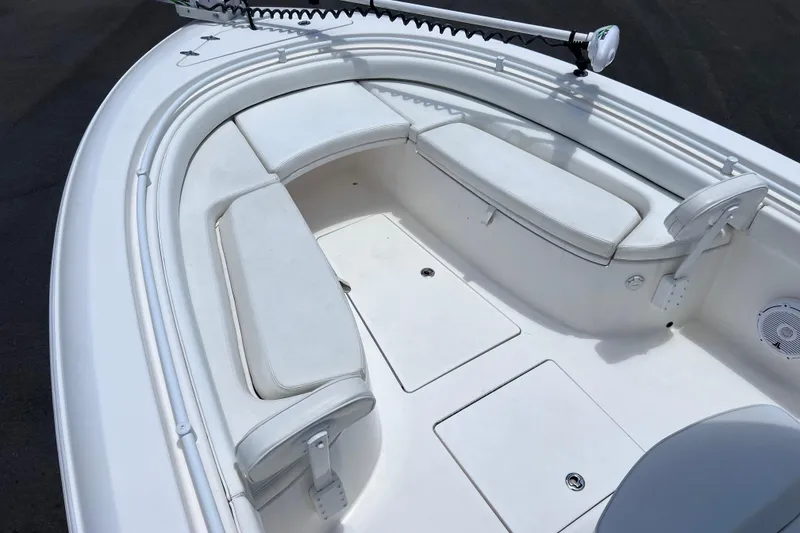 Slide: The Image of 2017 Contender 24 Sport boat interior with white cushioned seating and storage compartments. - 33