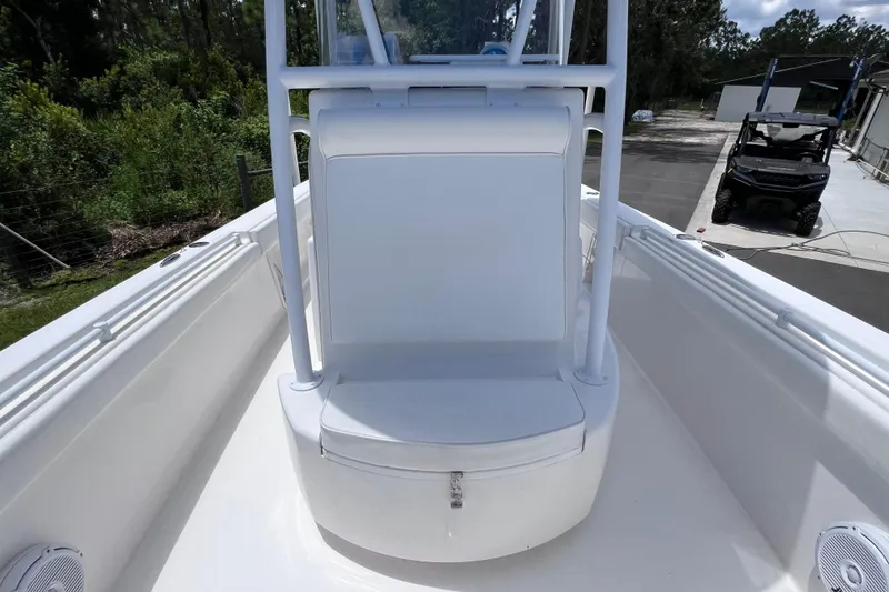 Slide: The Image of 2017 Contender 24 Sport boat interior with seating and storage, surrounded by lush greenery. - 41