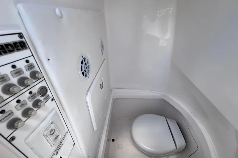 Slide: The Image of Interior of 2017 Contender 24 Sport boat featuring a compact marine toilet. - 45