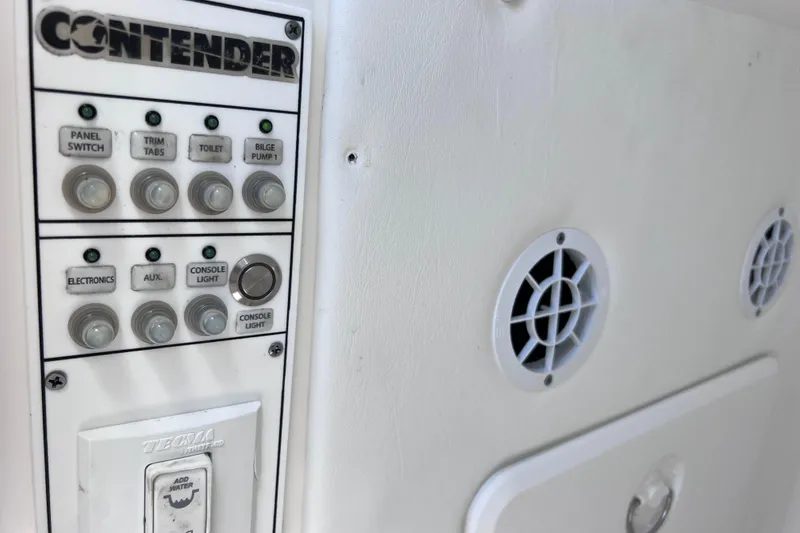 Slide: The Image of Control panel of a 2017 Contender 24 Sport boat with various switches and vents. - 46