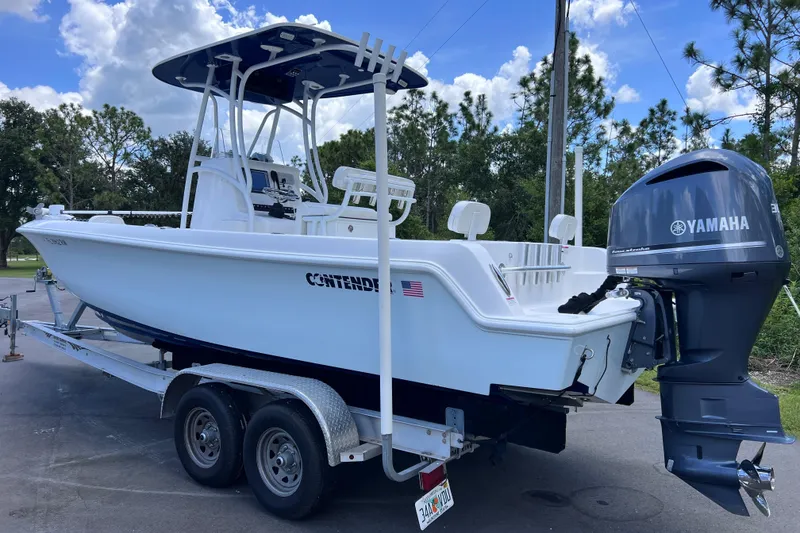 Slide: The Image of 2017 Contender 24 Sport boat on trailer with Yamaha outboard motor, parked outdoors. - 5