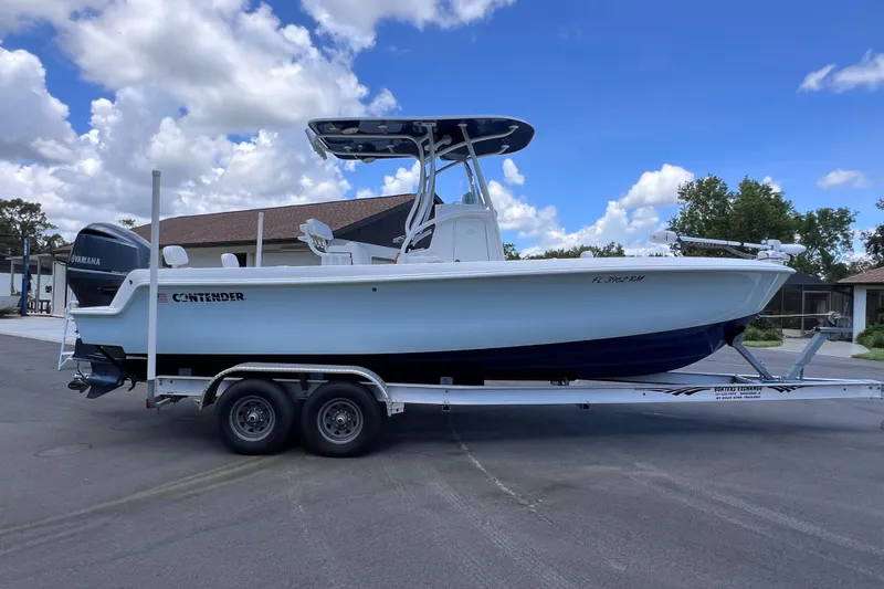 Slide: The Image of 2017 Contender 24 Sport boat on trailer, parked outdoors under a blue sky. - 8