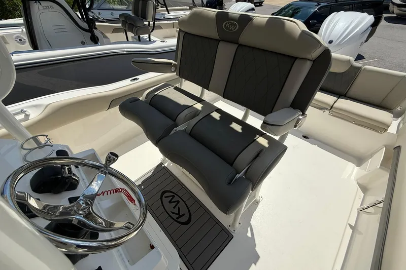 Slide: The Image of 2026 Key West 239 FS boat interior with steering wheel and cushioned seating. - 8