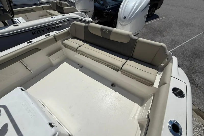 Slide: The Image of 2026 Key West 239 FS boat interior with beige seating and spacious deck area. - 9