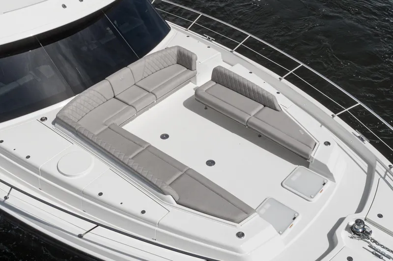 Slide: The Image of 2023 Riviera 64 Sports Motor Yacht deck with storage compartment and coiled hose. - 12