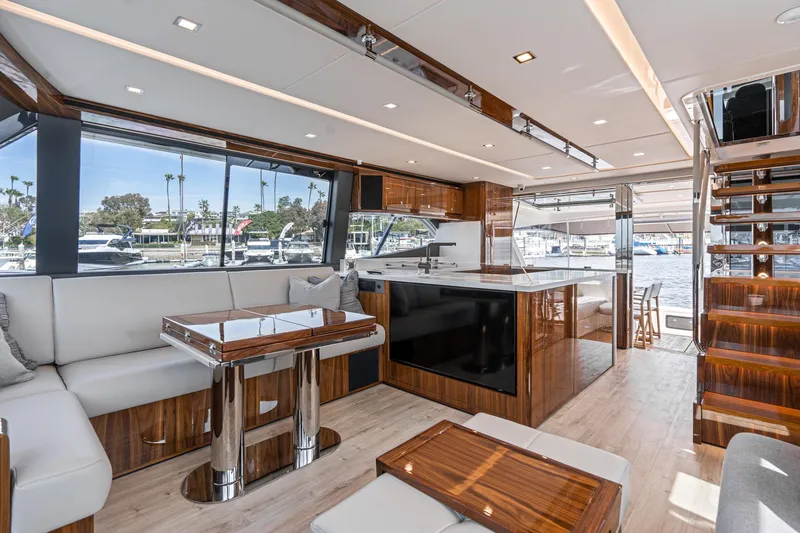 Slide: The Image of 2023 Riviera 64 Sports Motor Yacht with luxurious seating and helm, cruising on water. - 35