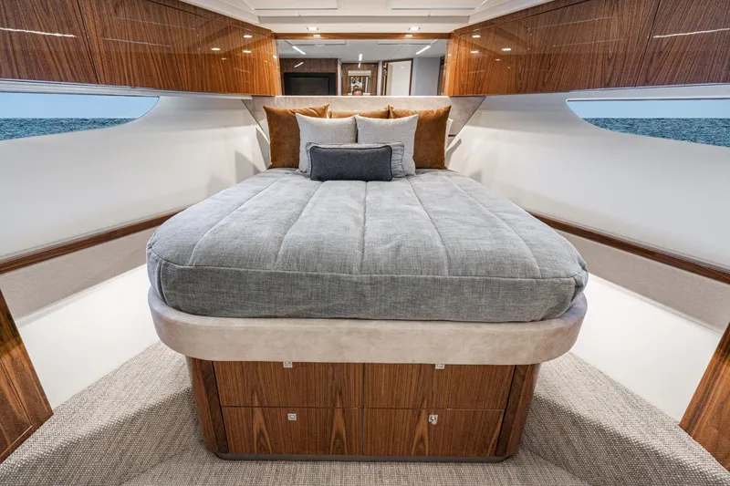 Slide: The Image of Luxurious bedroom interior of 2023 Riviera 64 Sports Motor Yacht with wood paneling and large window. - 46