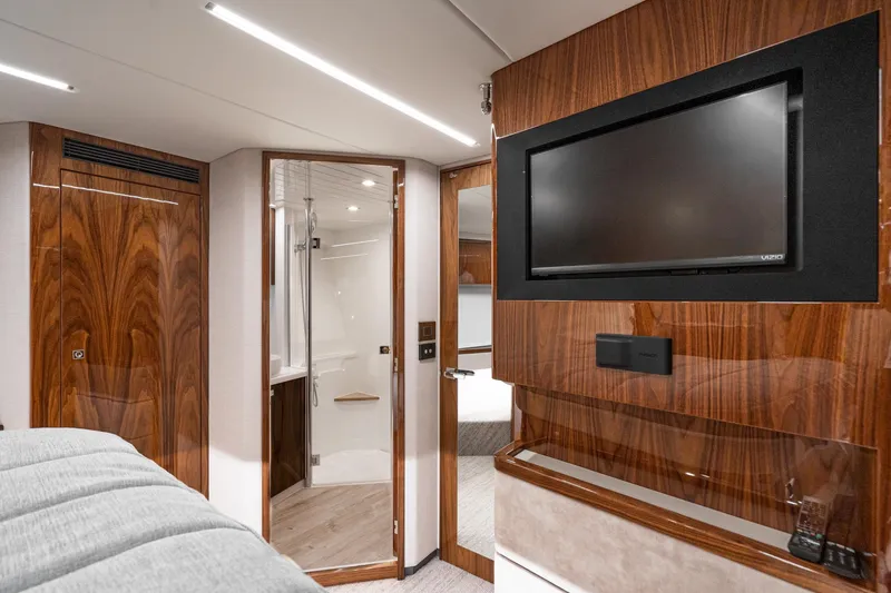 Slide: The Image of Luxurious bedroom interior of 2023 Riviera 64 Sports Motor Yacht with elegant wood finishes. - 48