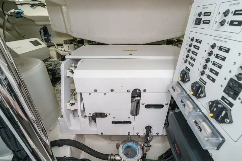 Slide: The Image of Engine room of 2023 Riviera 64 Sports Motor Yacht with control panels and machinery. - 58