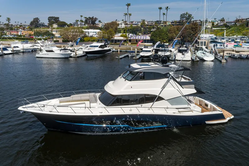 Slide: The Image of 2023 Riviera 64 Sports Motor Yacht with tender on water, showcasing luxury deck features. - 8