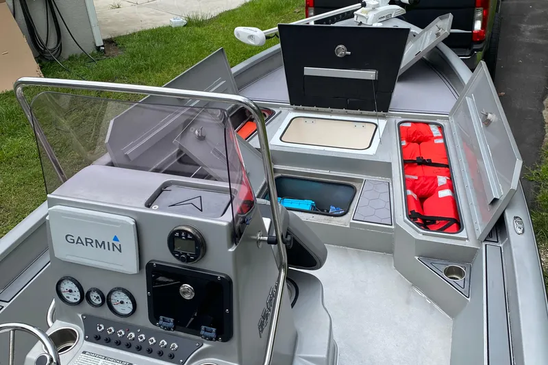 Slide: The Image of 2021 Avid 23 FS Magnum boat interior with Garmin navigation and storage compartments. - 6