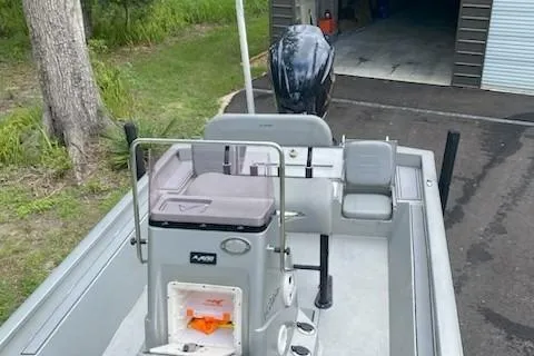 Slide: The Image of 2021 Avid 23 FS Magnum boat with outboard motor, parked near a garage. - 8