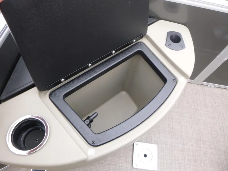 Slide: The Image of 2025 Sun Tracker Fishin' Barge 20 DLX storage compartment with cup holder and beige interior. - 13