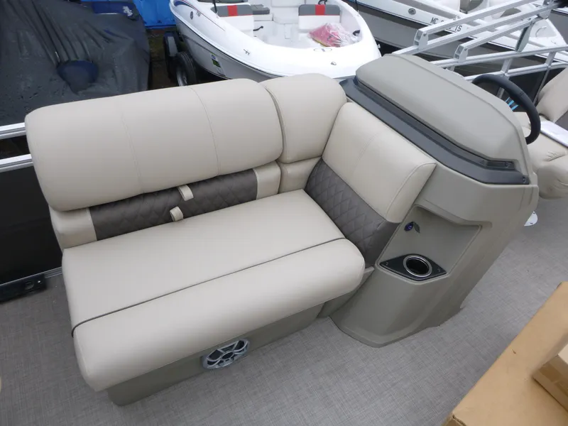 Slide: The Image of 2025 Sun Tracker Fishin' Barge 20 DLX boat interior with beige seating and steering console. - 7