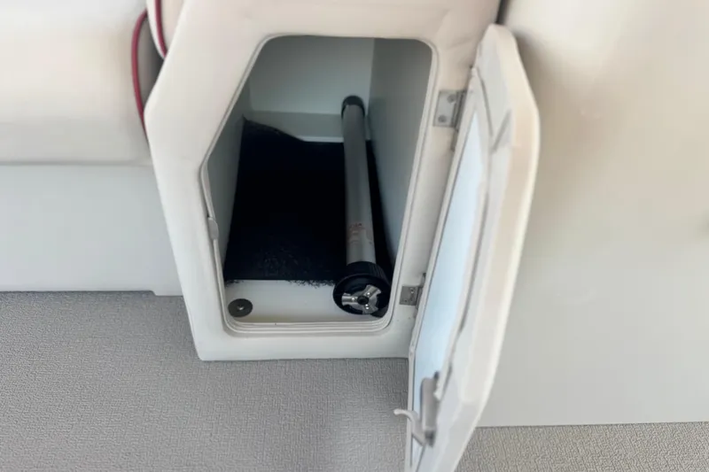Slide: The Image of Storage compartment in 2016 Apex Qwest 7518 LS boat, featuring a cylindrical object inside. - 12