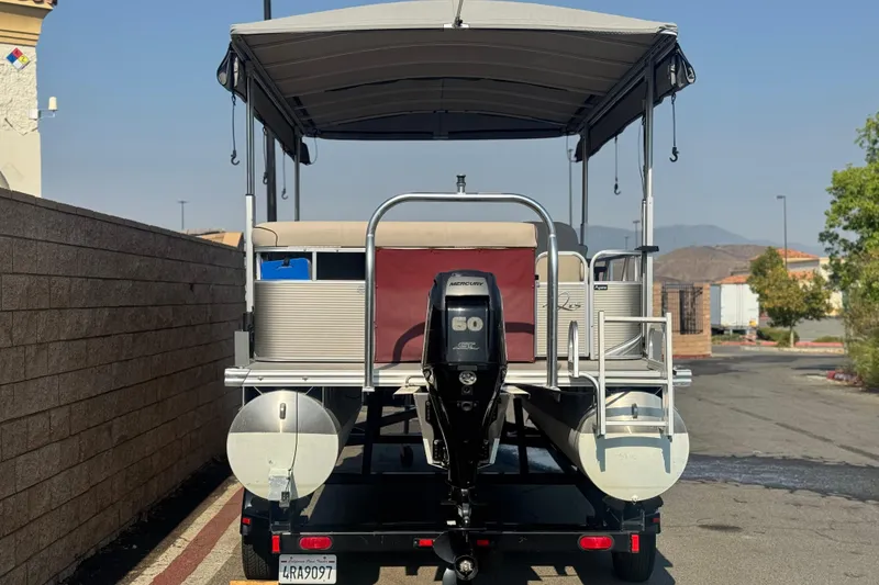 Slide: The Image of 2016 Apex Qwest 7518 LS pontoon boat with Mercury 60 outboard motor, parked on trailer. - 5