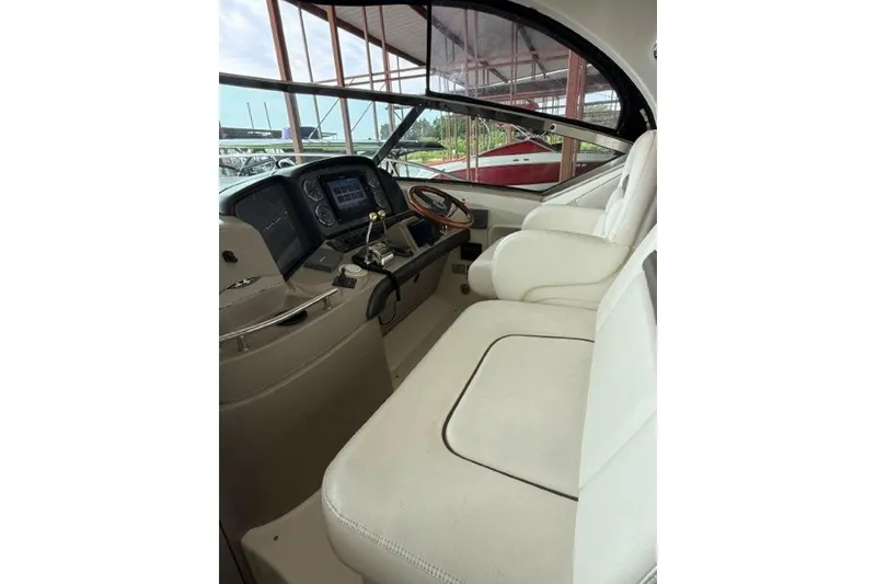 Slide: The Image of 2006 Sea Ray 38 Sundancer helm with white seating and modern dashboard controls. - 15