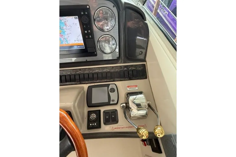 Slide: The Image of Helm controls of a 2006 Sea Ray 38 Sundancer with navigation display and gauges. - 18