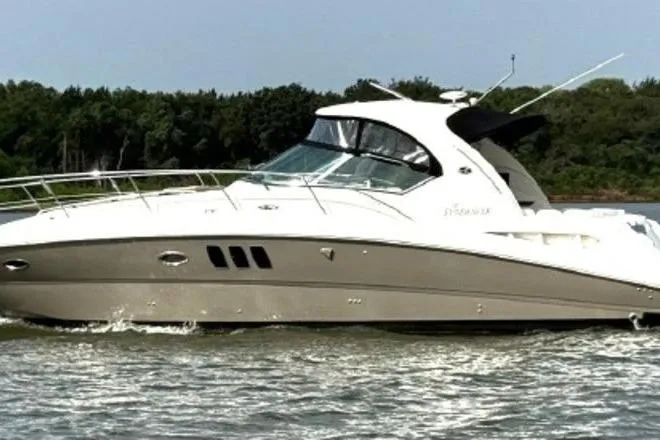 Slide: The Image of 2006 Sea Ray 38 Sundancer yacht cruising on a calm river with lush green trees. - 2