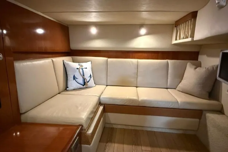 Slide: The Image of Interior of 2006 Sea Ray 38 Sundancer with beige seating and nautical-themed decor. - 25