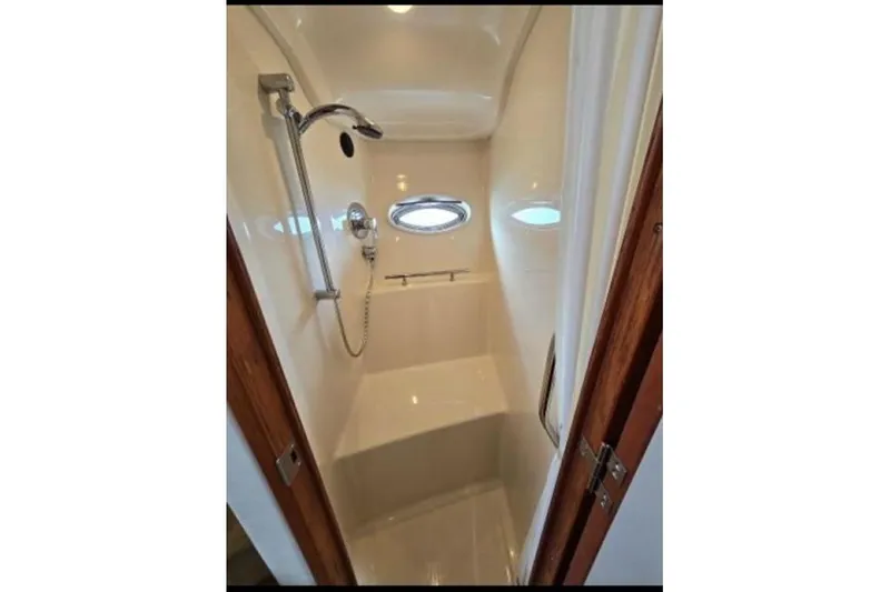 Slide: The Image of Compact shower area in 2006 Sea Ray 38 Sundancer yacht with porthole and handheld showerhead. - 31