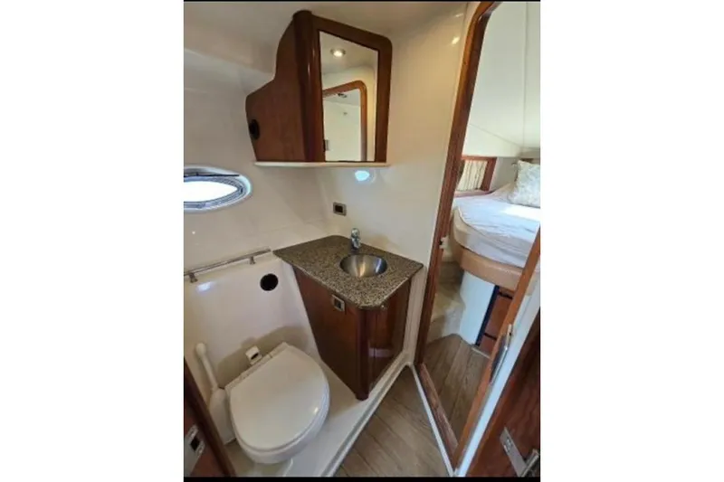 Slide: The Image of 2006 Sea Ray 38 Sundancer bathroom with sink, toilet, and wood cabinetry. - 33