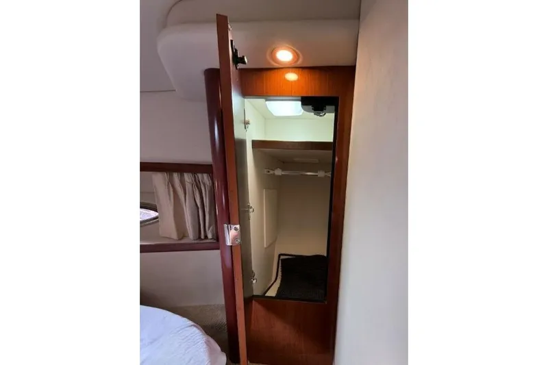 Slide: The Image of Interior of 2006 Sea Ray 38 Sundancer showing open closet with mirror and lighting. - 38