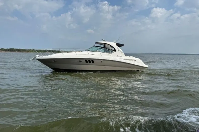 Slide: The Image of 2006 Sea Ray 38 Sundancer yacht cruising on open water under a cloudy sky. - 42