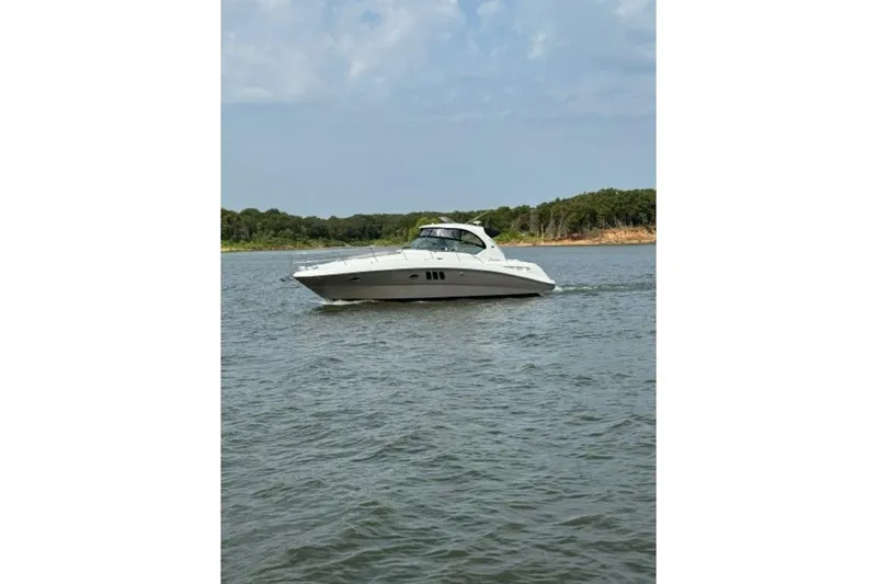 Slide: The Image of 2006 Sea Ray 38 Sundancer cruising on a calm lake under a partly cloudy sky. - 46